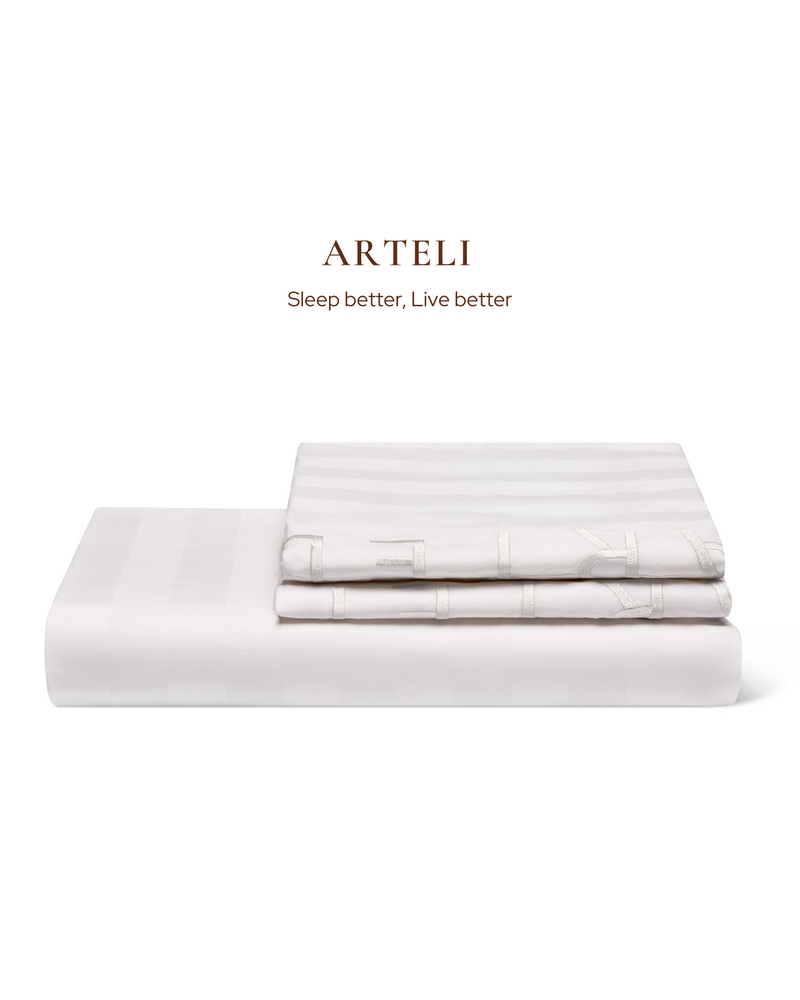 Close-up of ARTELI 100% cotton bedding - soft white duvet cover and pillowcases
